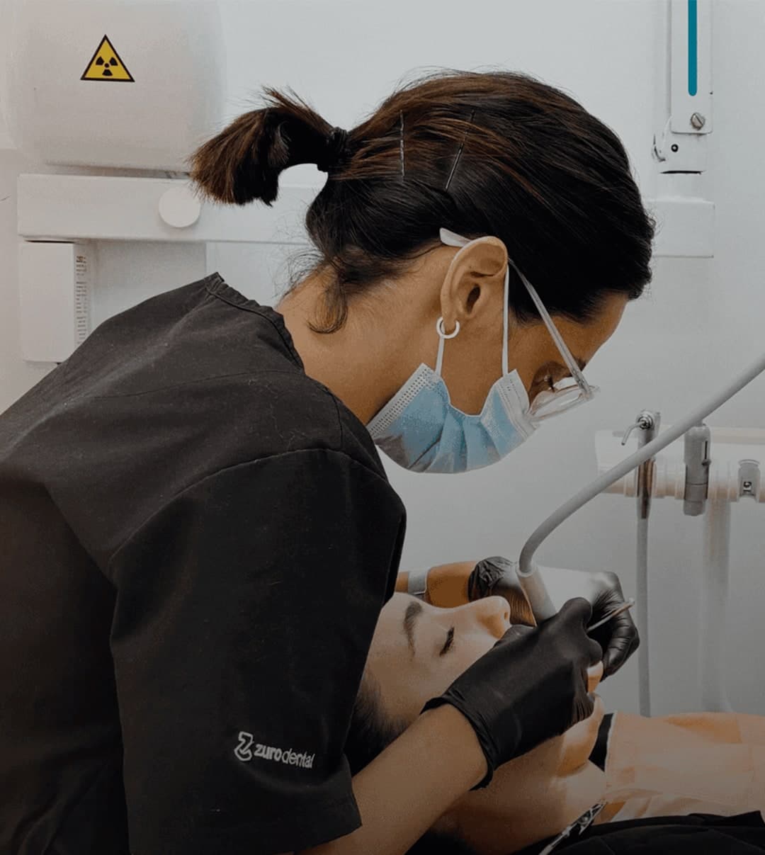 Odontóloga de Zuro Dental realizando una limpieza dental a un paciente