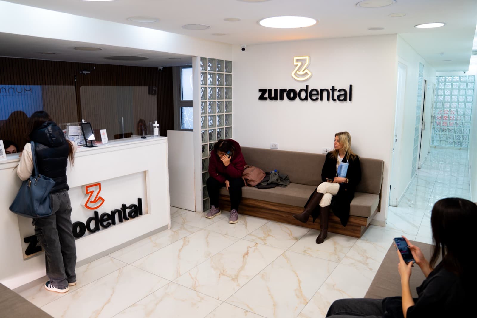 Recepción de Zuro Dental en Recoleta, con pacientes en la sala de espera